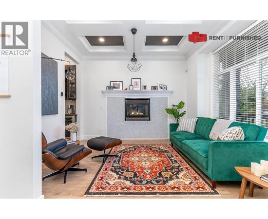 A living room with a green couch and a fireplace.