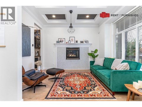 A living room with a green couch and a fireplace.