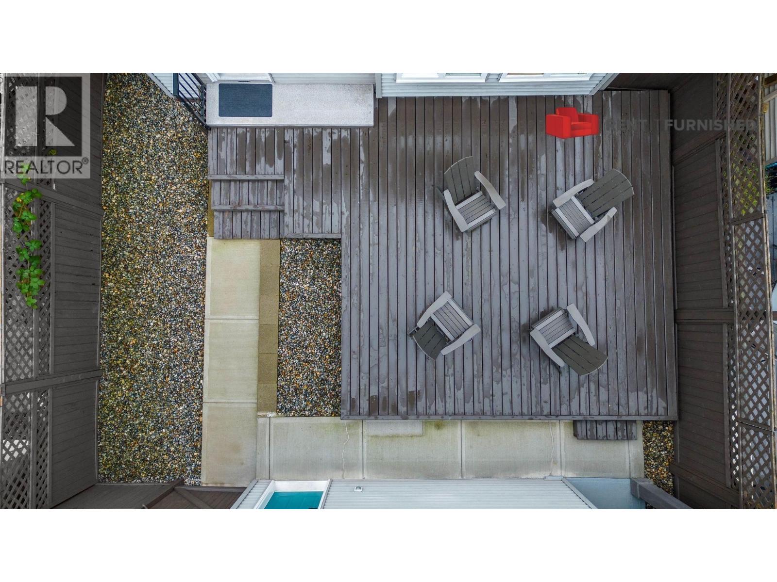 A grey wall with four square cutouts and a pool in the middle.