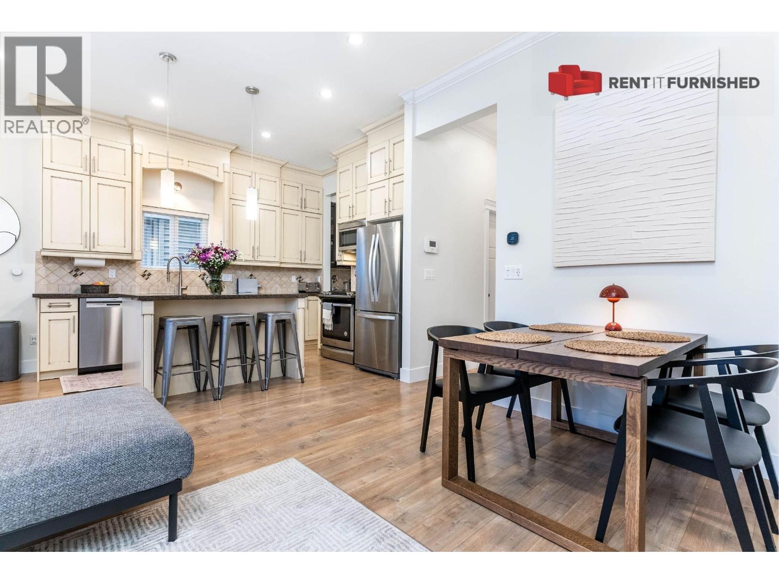 A kitchen with a table and chairs in the middle of the room.