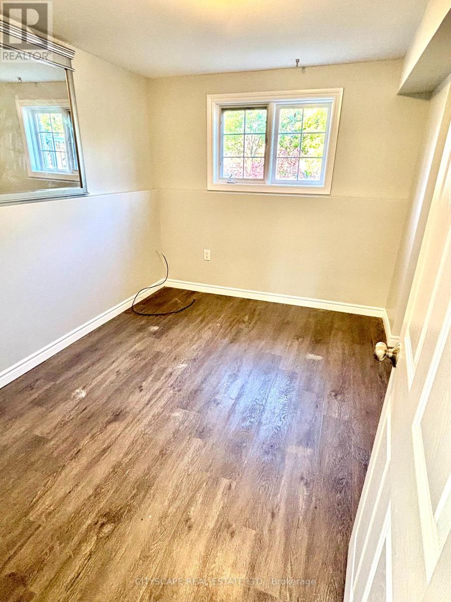 A room with wooden flooring and a window.