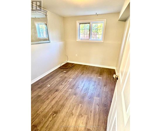 A room with wooden flooring and a window.