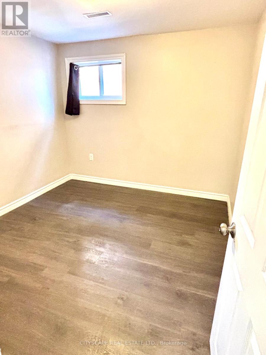 A room with wooden flooring and a window.