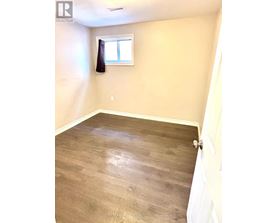 A room with wooden flooring and a window.