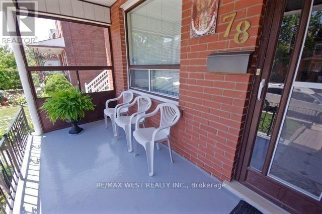 A balcony with chairs and a plant.