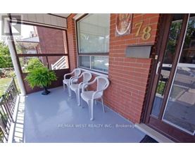 A balcony with chairs and a plant.