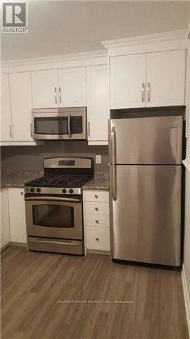 A kitchen with a stainless steel refrigerator, oven, and microwave.