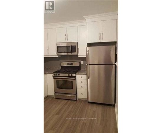 A kitchen with a stainless steel refrigerator, oven, and microwave.