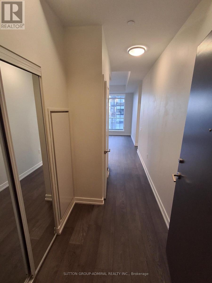 A hallway with wood floors and white walls.