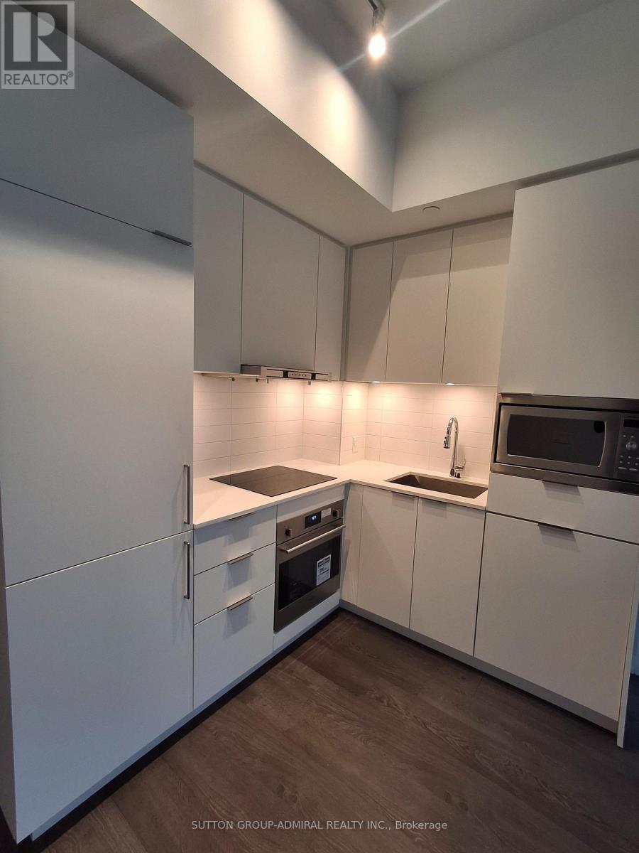 A modern kitchen with white cabinets and appliances.
