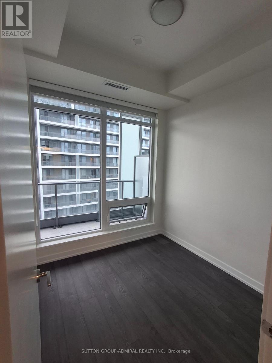 A room with a large window and a view of a building across the street.