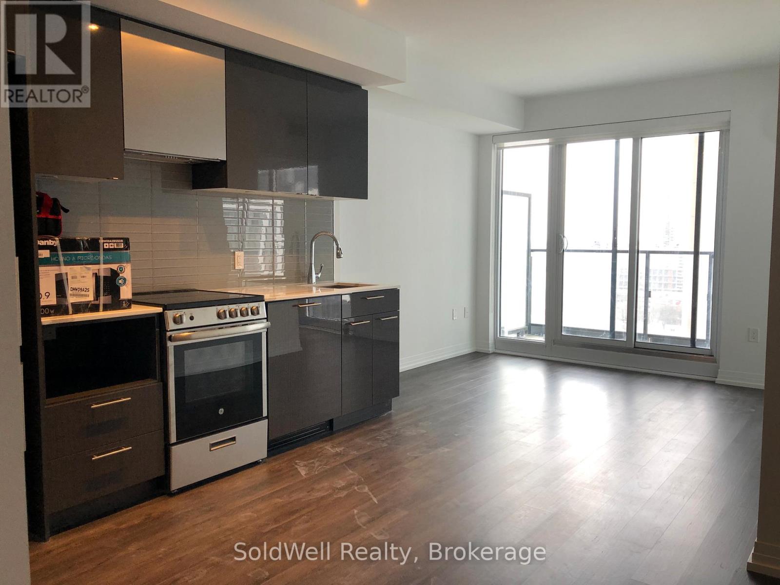 A kitchen with a stove top oven and a refrigerator.