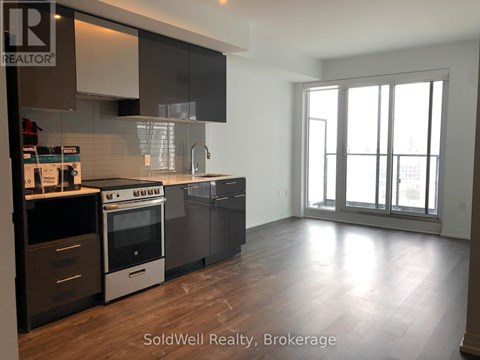 A kitchen with a stove top oven and a refrigerator.