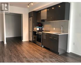 A kitchen with dark wood floors and modern appliances.