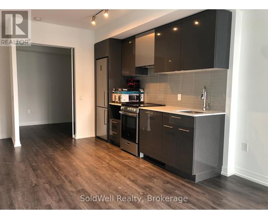 A kitchen with dark wood floors and modern appliances.