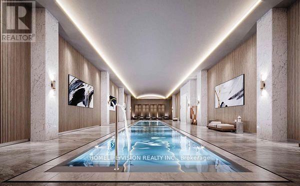 A long, narrow indoor swimming pool with a lighted floor.