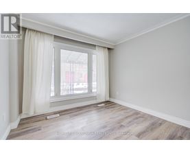 A room with a large window and wooden flooring.