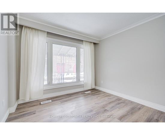 A room with a large window and wooden flooring.