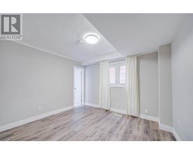 A room with a door and a window with white curtains.