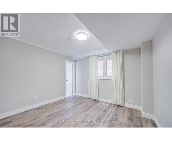 A room with a door and a window with white curtains.