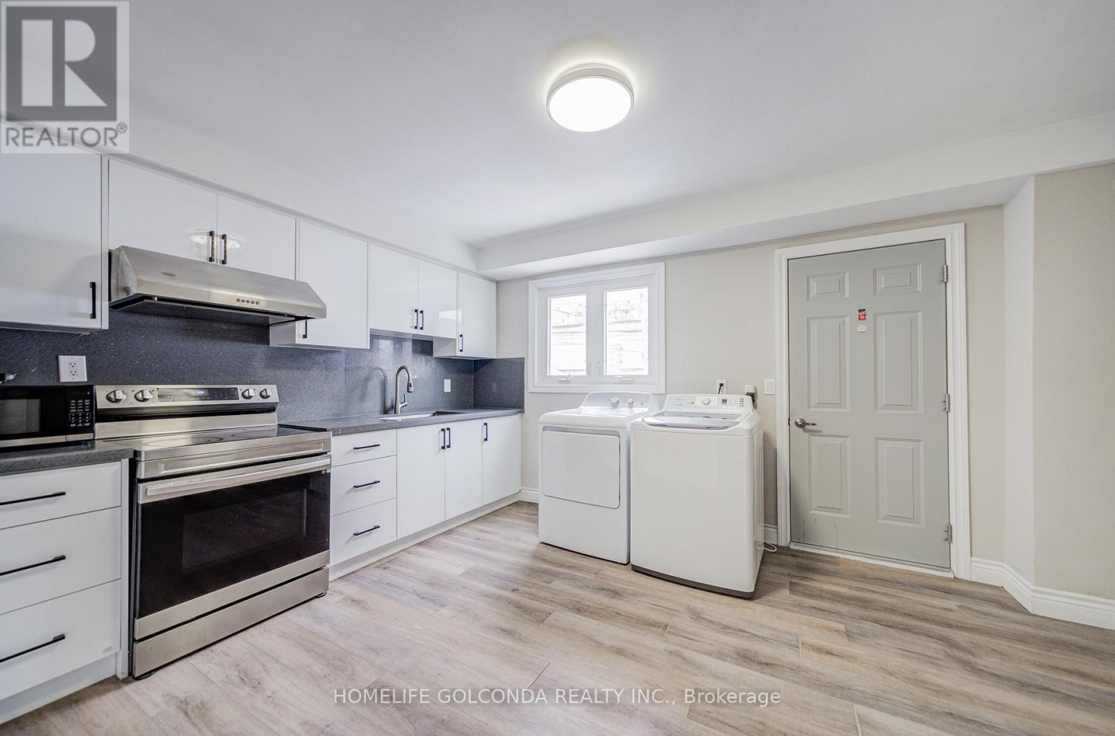 A kitchen with white cabinets and appliances.