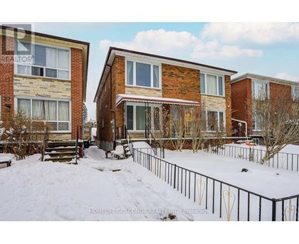 A snow-covered ground with a building in the background.
