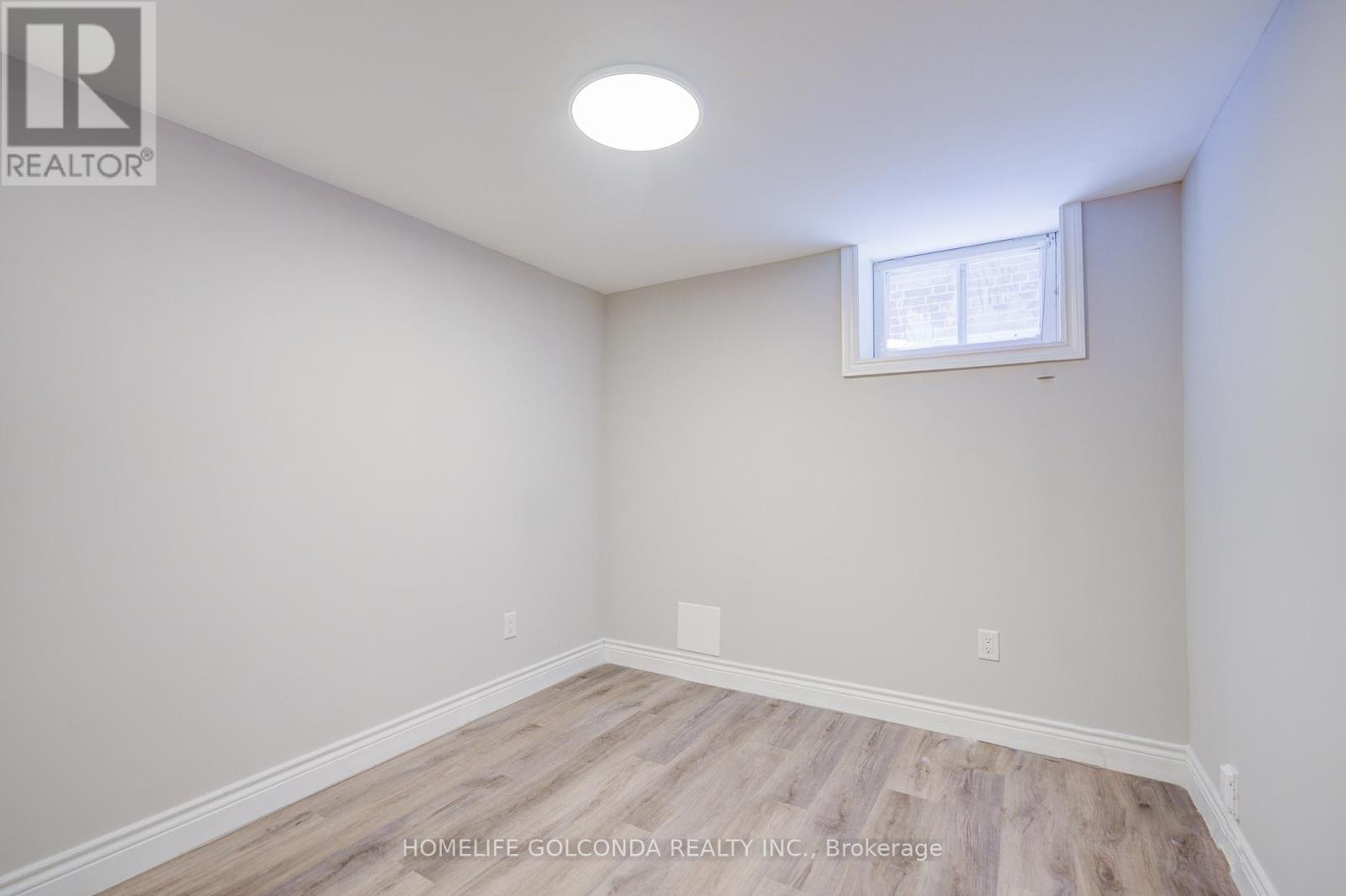 A room with a window and wooden flooring.