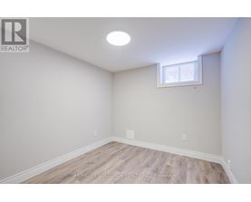 A room with a window and wooden flooring.