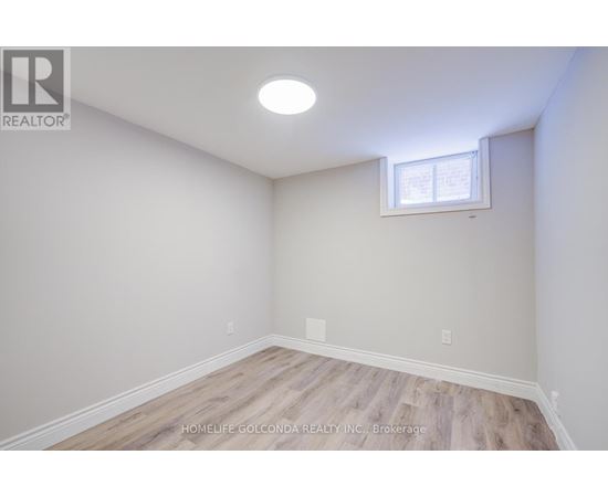 A room with a window and wooden flooring.