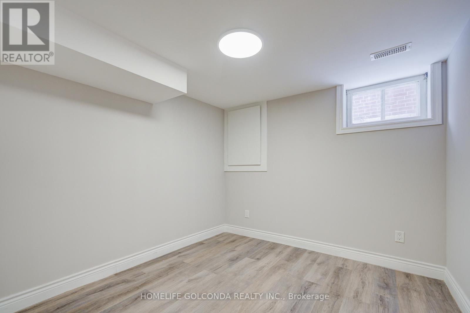A room with a window and a light on the ceiling.