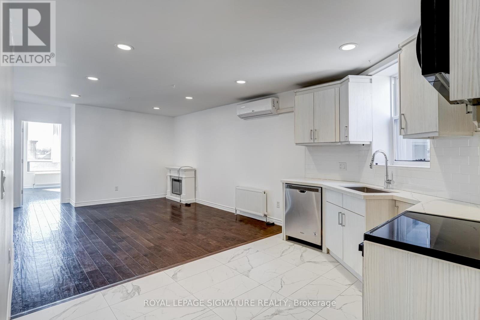 A kitchen with white cabinets and a black countertop.