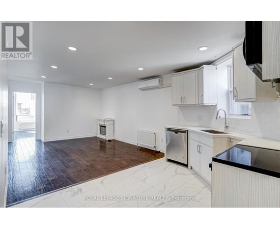 A kitchen with white cabinets and a black countertop.