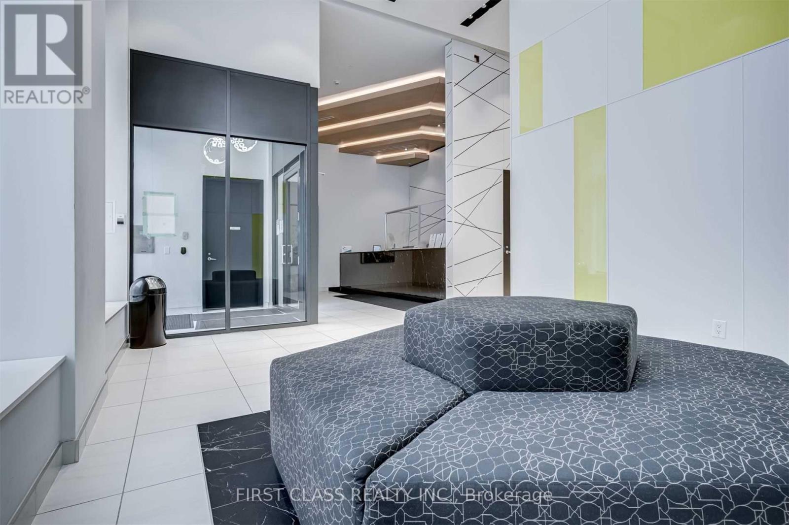 A modern bedroom with a bed, a chair, and a glass door.