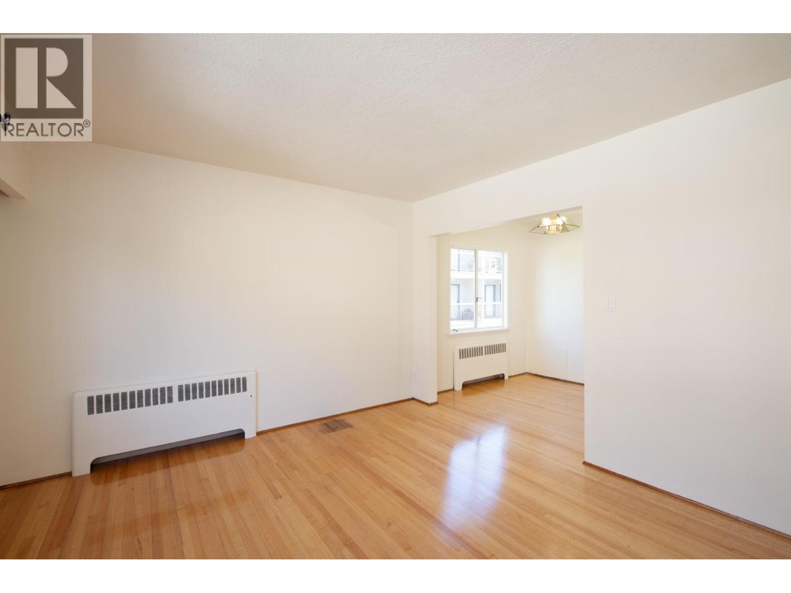 A room with a white wall and a window with a white frame.