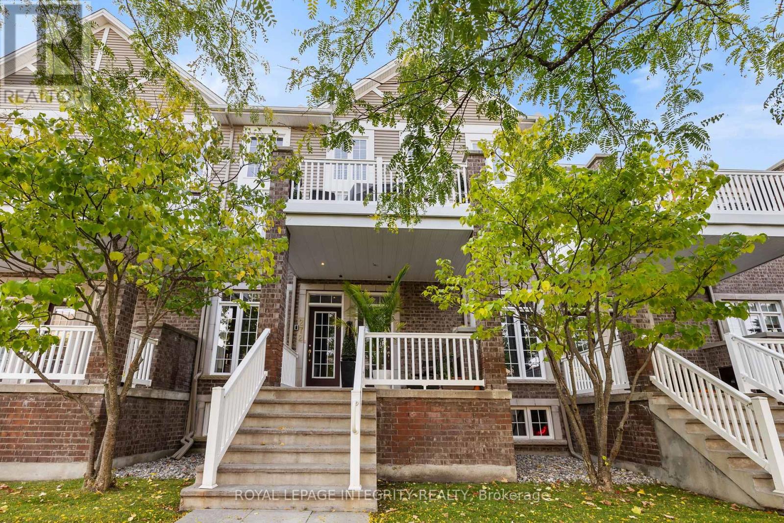 A house with a front porch and a tree in front of it.