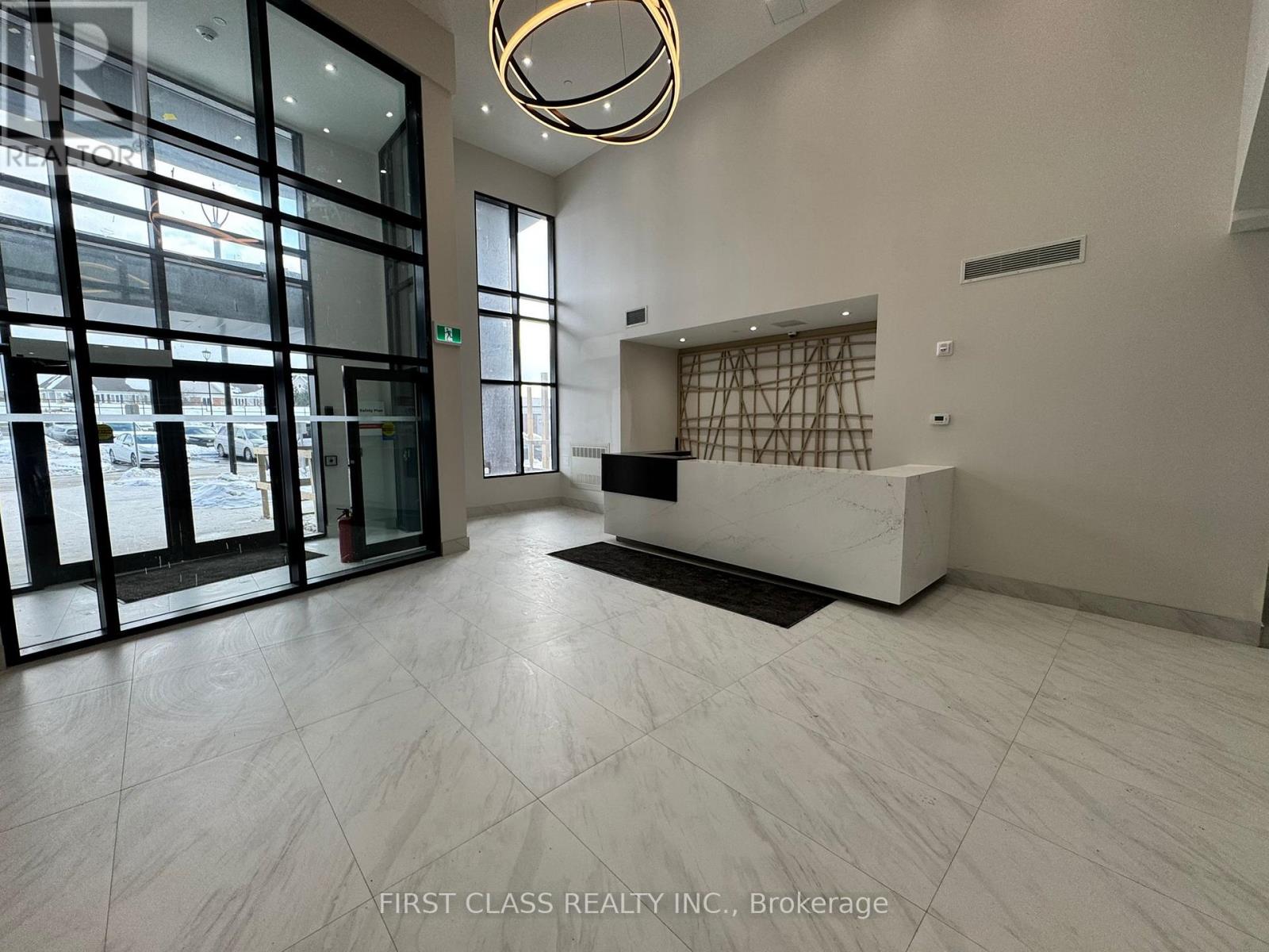 A reception area with a white reception desk and a large window.