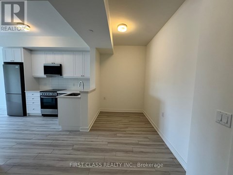 A kitchen with white cabinets and a stainless steel refrigerator.
