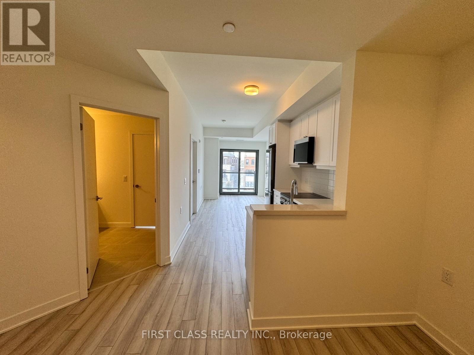 A well-lit hallway with a kitchen area on the right.