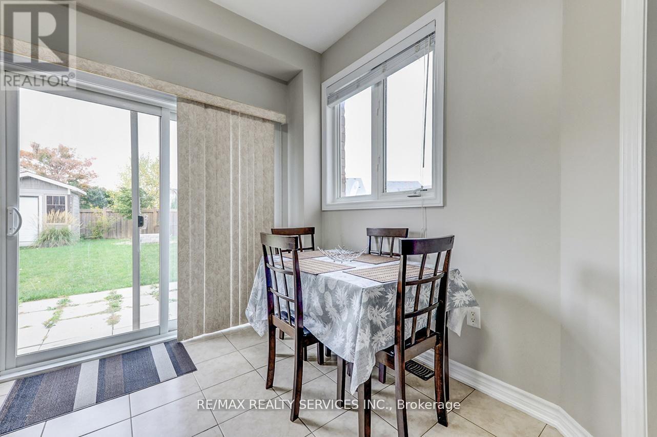 A dining room with a table set for two and a view of a backyard.