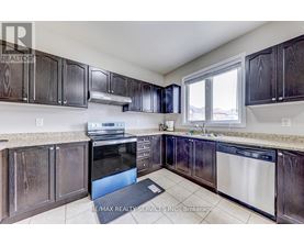 A kitchen with dark wood cabinets and a stainless steel dishwasher.