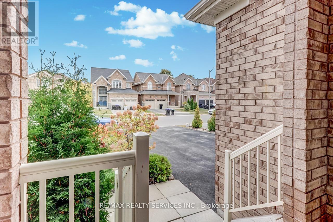 A view from a balcony overlooking a residential area with houses and trees.