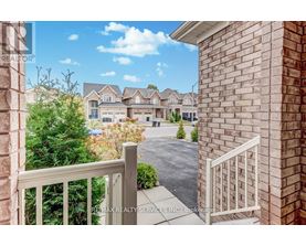 A view from a balcony overlooking a residential area with houses and trees.