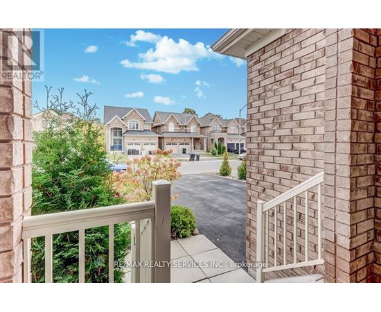 A view from a balcony overlooking a residential area with houses and trees.