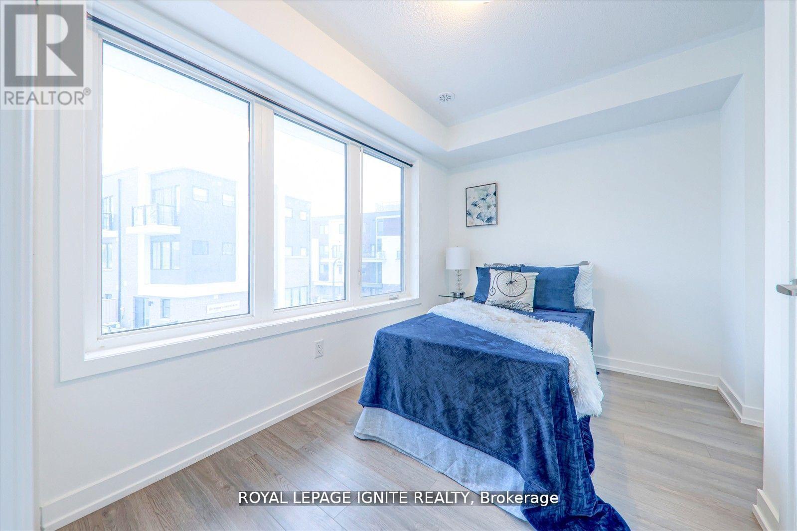A bedroom with a bed covered in a blue blanket and a clock on the wall.