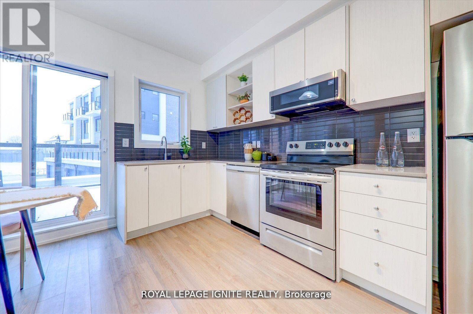 A kitchen with white cabinets and a stainless steel refrigerator.