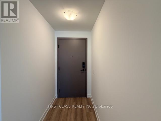 A hallway with a door and a light on the ceiling.