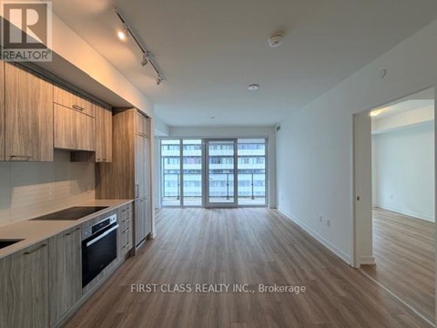 A kitchen with wooden cabinets and a large window.