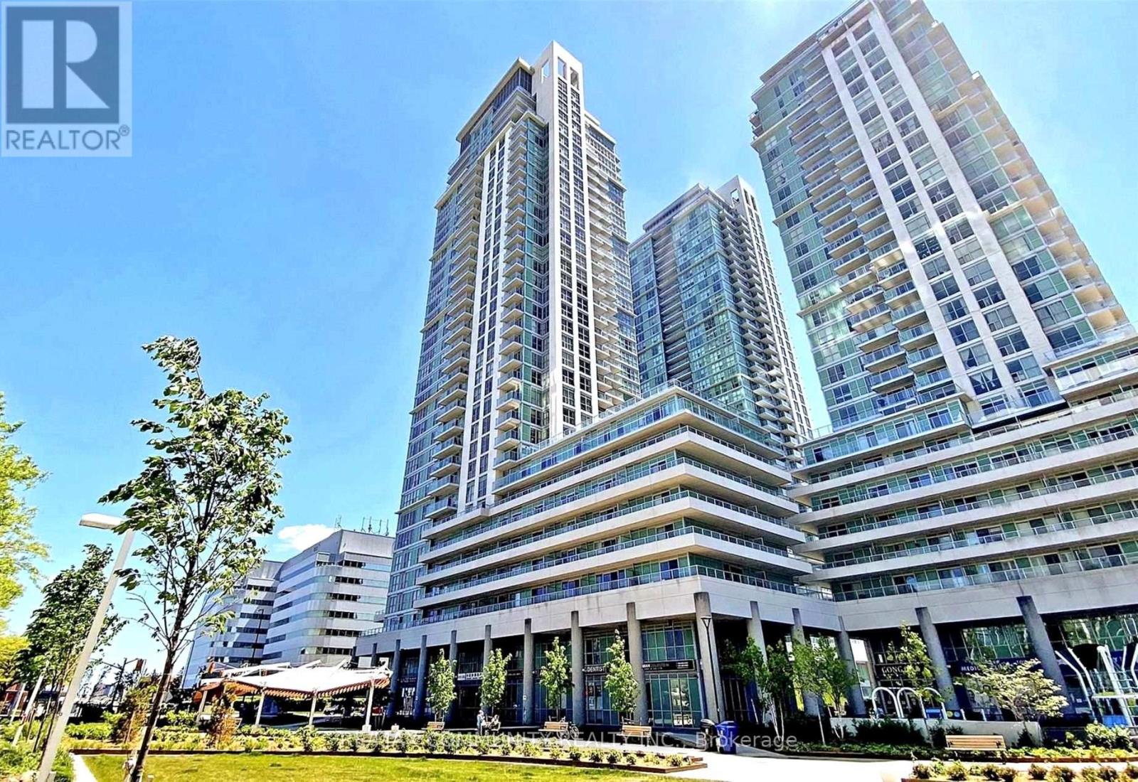 A modern building with glass windows and a logo of REALTOR in the top left corner.