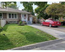 A red car is parked on the street in front of a house.