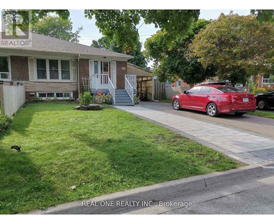 A red car is parked on the street in front of a house.